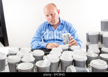 Overworked businessman drinking too much coffee Stock Photo
