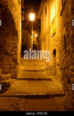 Illuminated alley in the night in a medieval village. Èze-Village, Alpes-Maritimes, French Riviera, France. Stock Photo