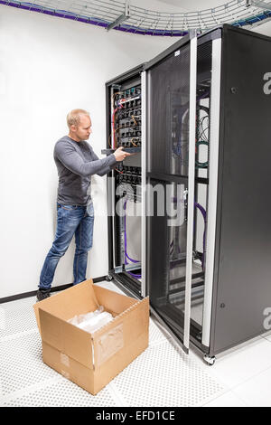 IT engineer installs network switch in datacenter Stock Photo