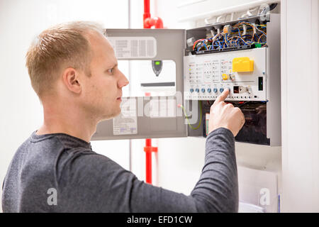 Technician checks fire panel in data center Stock Photo