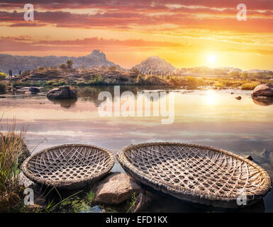 Round shape boats on Tungabhadra river at sunset sky in Hampi, Karnataka, India Stock Photo