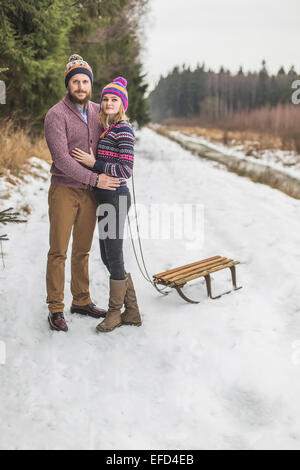 Young couple having a sled winter forest walk Stock Photo