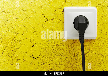 Wall plug socket on cracked colored wall background Stock Photo