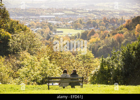 People enjoy the view from a bench by the Clifton Suspension Bridge in Bristol on a sunny day. Stock Photo