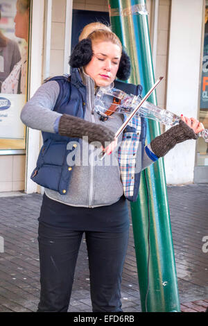 A young woman busker or street musician playing an electronic violin in Cleveland Centre Middlesbrough Stock Photo