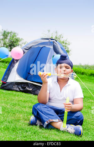 1 indian child boy park Picnic playing Bubble Wand Stock Photo