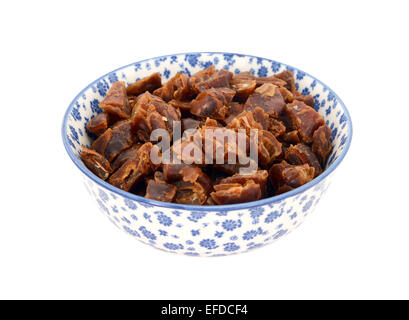 Chopped dates in a blue and white porcelain bowl with a floral design, isolated on a white background Stock Photo