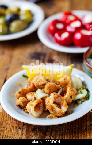Tapas of squid, stuffed peppers and olives Stock Photo