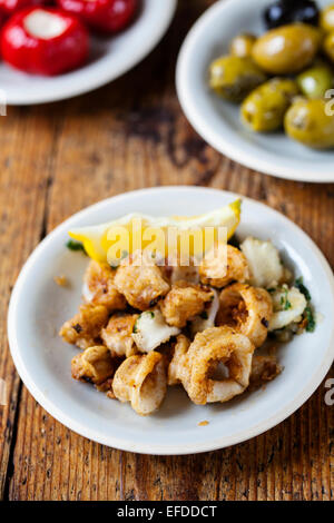 Tapas of squid, stuffed peppers and olives Stock Photo
