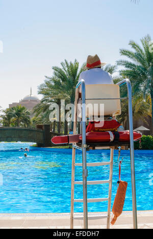 Lifeguard on duty at the outdoor adults-only swimming pool at the Emirates Palace Hotel, Abu Dhabi Stock Photo