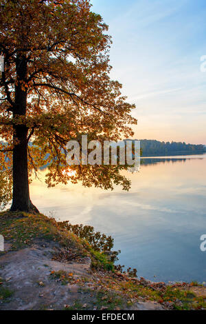 Autumn sunset on the lake with reflection of sun in water Stock Photo