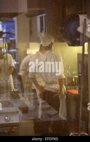 Chefs at work behind a gauze screen in the Larte restaurant in Milan, Italy. Stock Photo
