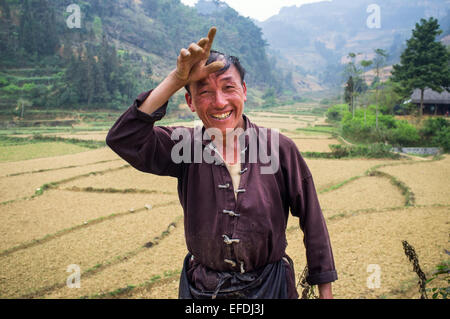 Portrait of Vietnamese Farmer in front of rice paddies, near Bac Ha, Vietnam, Asia Stock Photo