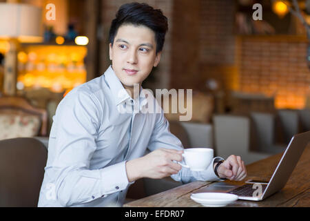 Young man using laptop in cafe Stock Photo