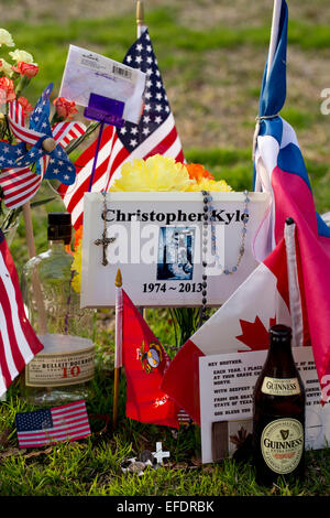 Austin, Texas, USA. 1st February, 2015. Memorabilia adorns the Texas State Cemetery grave of U.S. Navy Seal sniper Chris Kyle who died in 2013.  Kyle, the most prolific sniper in U.S. history, is the subject of the popular movie 'American Sniper'. Credit:  Bob Daemmrich/Alamy Live News Stock Photo