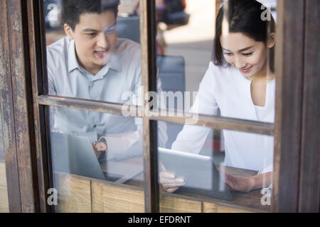 Young man and woman using digital tablet in cafe Stock Photo