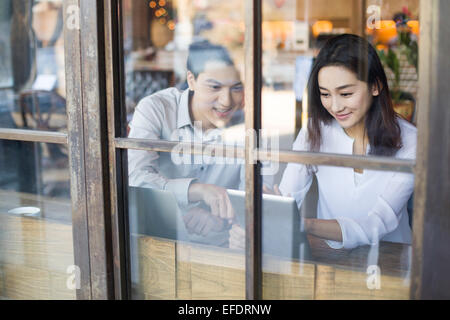 Young man and woman using digital tablet in cafe Stock Photo