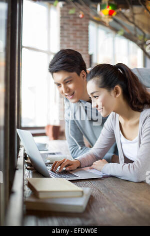 Young man and woman using laptop in cafe Stock Photo