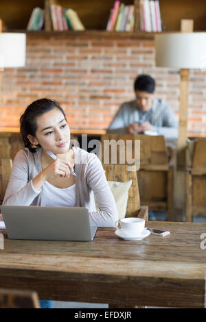 Young woman using laptop in cafe Stock Photo
