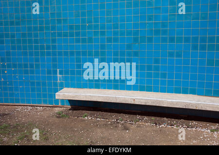 Wall with blue tiles and concrete bench near the sea. Stock Photo