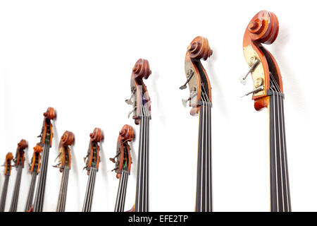 row of double basses details leaning against a wall Stock Photo