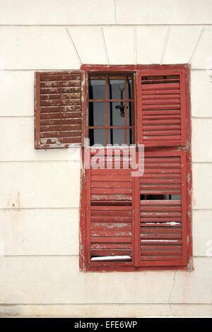 old damaged wooden blinds on an abandoned house Stock Photo