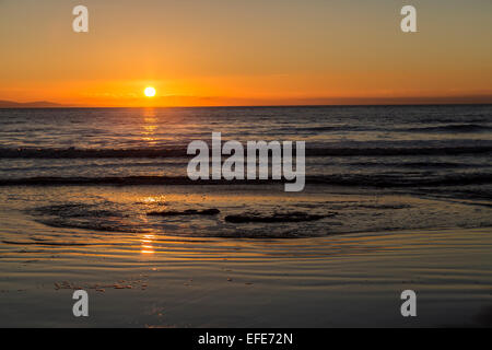 Sunset over waves on beach, Southerndown, Glamorgan Heritage Coast, Wales, UK Stock Photo
