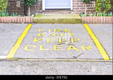 Fire exit sign on the ground in a car park Stock Photo