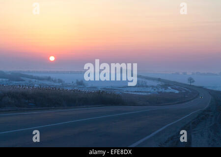 sunrise on the winter road Stock Photo