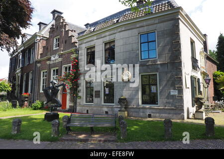 Park bench and sculpture in front of a small boutique hotel on the outskirts of Amsterdam. Stock Photo