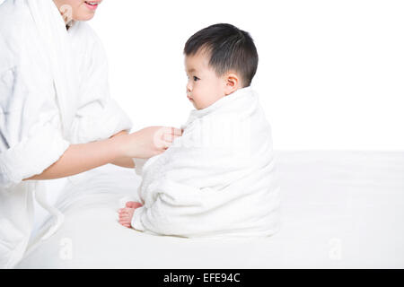 Mother wrapping baby in blanket Stock Photo