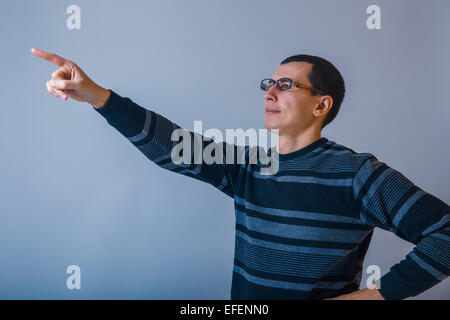 European-looking male of about thirty points a finger upward on Stock Photo