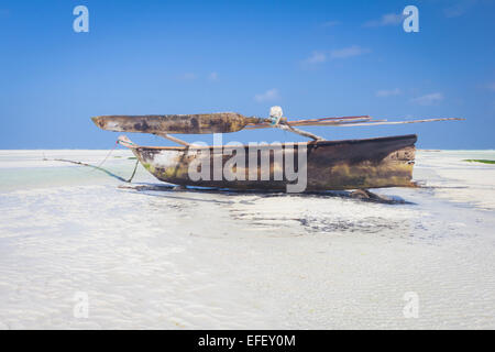 Dhow wooden boat lying dry at low tide on a beach at the Indian Ocean Stock Photo