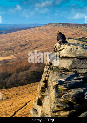 Climber about to descend sheer cliff face on rocks at Stanage  Edge Peak District National Park Derbyshire UK Stock Photo
