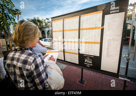 Santa Barbara, California, USA. 1st Feb, 2015. A festival attendee takes notes on upcoming screenings and other events outside the Metro 4 theatre at the 30th annual Santa Barbara International Film Festival. Credit:  Scott London/Alamy Live News Stock Photo