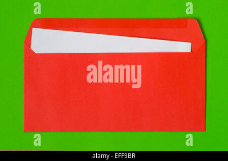open red envelope with  blank paper on green background Stock Photo