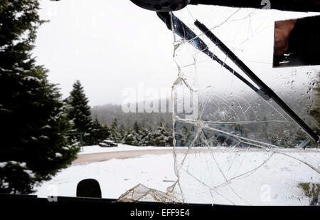 View of  trees covered with snow through a broken front shield car window in Tymfristos a mountain in the eastern part of Evrytania and the western part of Phthiotis, Greece. The mountain is a part of the Pindus mountain range Stock Photo