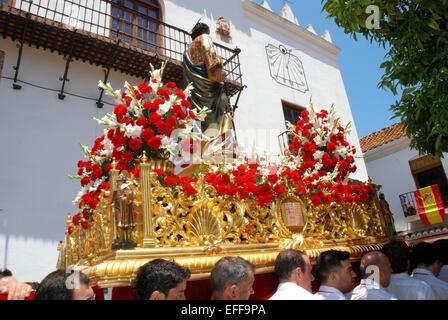 Bearers carrying a Statue of Saint Bernard on a float through the town streets during the Romeria San Bernabe, Marbella, Spain. Stock Photo
