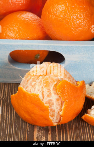 Tangerine fruits in a timber box on a wooden table Stock Photo