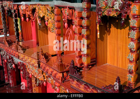 Buddhist spirit houses are on display for sale at a shop on a city street in Kampong Cham, Cambodia. Stock Photo