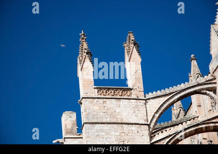 Towers on the cathedral La Seu with a symbolic white bird soaring high on blue sky, Palma de Mallorca, Balearic islands, Spain. Stock Photo