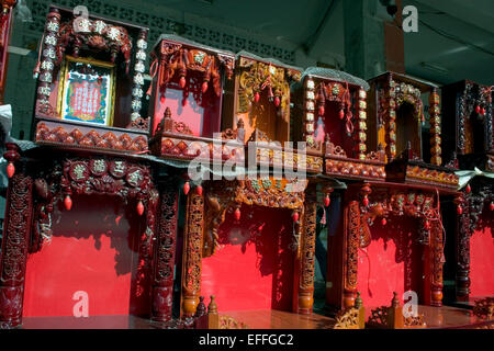 Buddhist spirit houses are on display for sale at a shop on a city street in Kampong Cham, Cambodia. Stock Photo