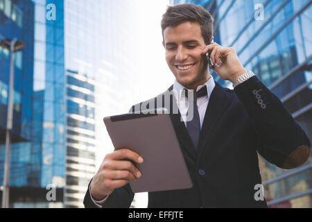 Businessman using a mobile phone and digital tablet Stock Photo