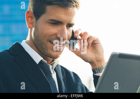 Businessman using a mobile phone and digital tablet Stock Photo