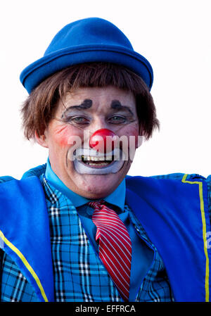 Circus clown in traditional costume with a red nose isolated against a white background. Stock Photo