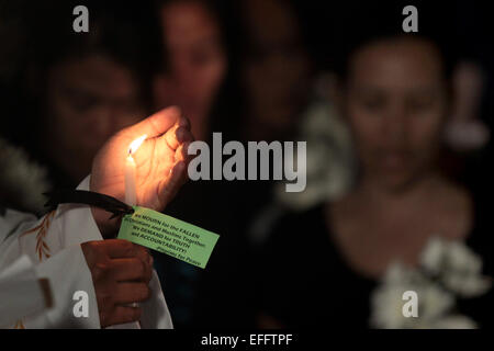 (150203) -- QUEZON CITY, Feb. 3, 2015 (Xinhua) -- People light candles and offer flowers and prayers for the slain 49 members of the Philippine National Police Special Action Force (PNP-SAF) at the gate of the PNP Headquarters in Quezon City, the Philippines, Feb. 3, 2015. There was lack of coordination and planning between the military forces and the leadership of the PNP-SAF during the violent clash in Mamasapano, Maguindanao on Jan. 25, chief of the Armed Forces of the Philippines said on Tuesday. (Xinhua/Rouelle Umali) (lmz) Stock Photo