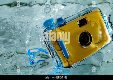 Photo of yellow waterproof camera in water. Stock Photo