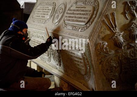 Wolfenbuettel, Germany. 19th Jan, 2015. A restorer works on the zinc coffin from the Welfen family in the princely crypt below the main church in Wolfenbuettel, Germany, 19 January 2015. In spring, all 28 coffins in the princely crypt will be restored. Over the course of the year, the crypt will open an exhibition for visitors. Photo: Peter Steffen/dpa/Alamy Live News Stock Photo