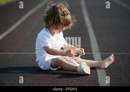 beautiful little girl learning to tie shoelaces Stock Photo