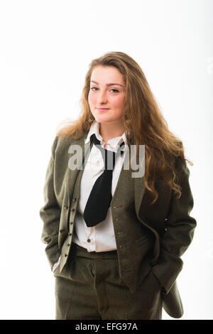 Cross-dressing / Masculinity : A pretty fourteen 14 year old teenage girl with long brown hair, wearing a man's masculine clothes - green three piece traditional tweed suit shirt and tie  UK Stock Photo